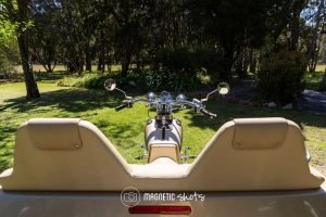View From The Rear Seat Of A Motorcycle Parked On A Lawn, Surrounded By Trees And Greenery.